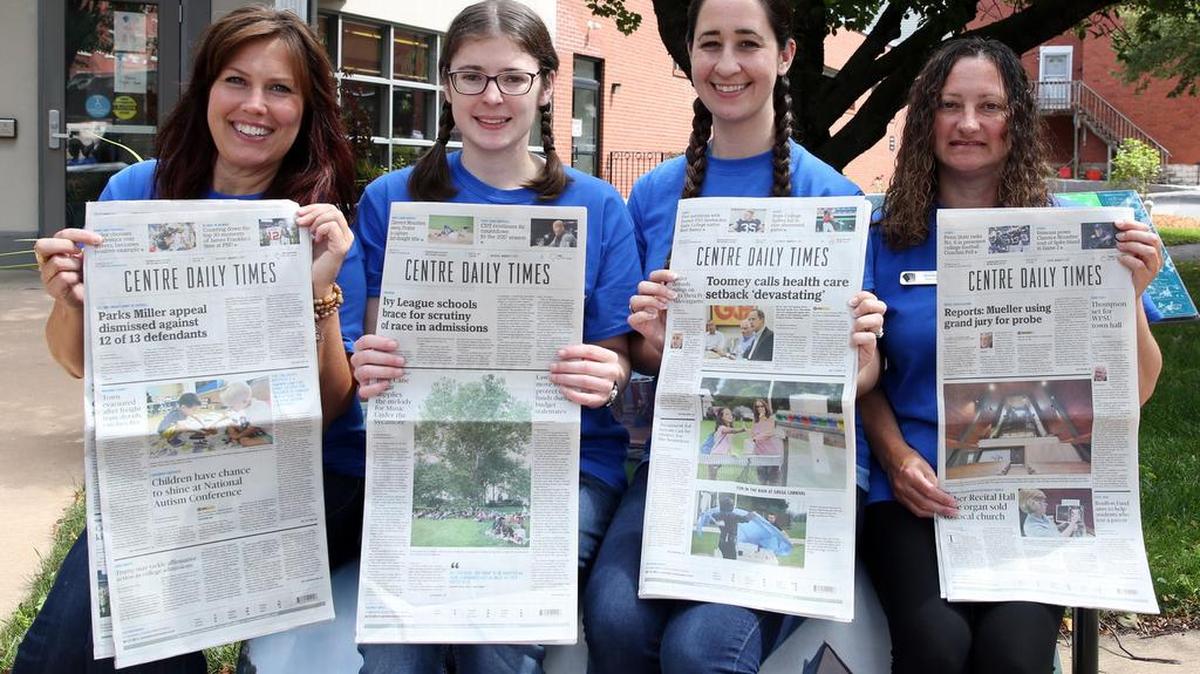 From left, Jenny Cifelli, Lisa Shaffer, Laura Sarge and Jennifer Freed hold up the Centre Daily Times on Tuesday the Centre County Library in Bellefonte. Library employees and volunteers will deliver the CDT during Grange Fair.