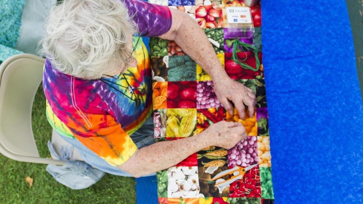 Edna Kotrola sews a backing for her tent during the 2016 FarmFest.