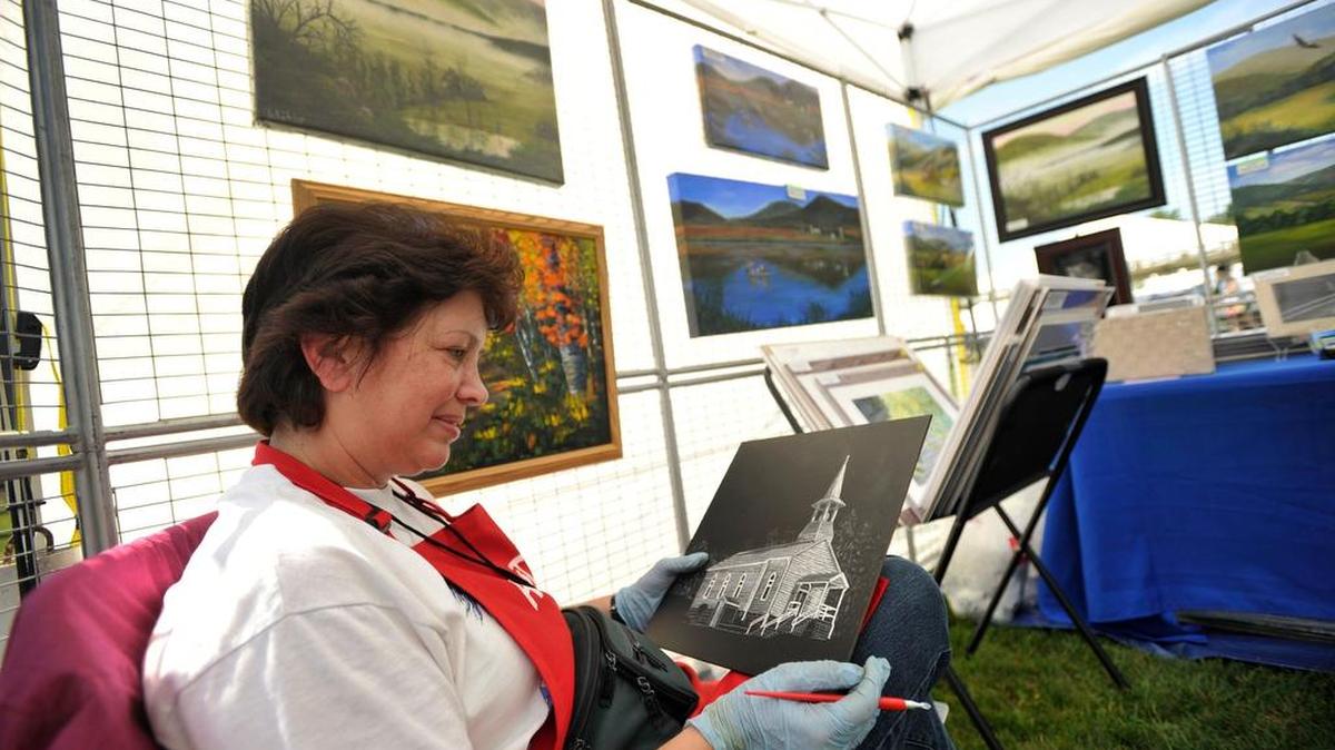 Lynn Kibbe, of Trout Run, works on her scratchboard art during the 2015 Bellefonte Arts & Crafts Fair in Talleyrand Park.