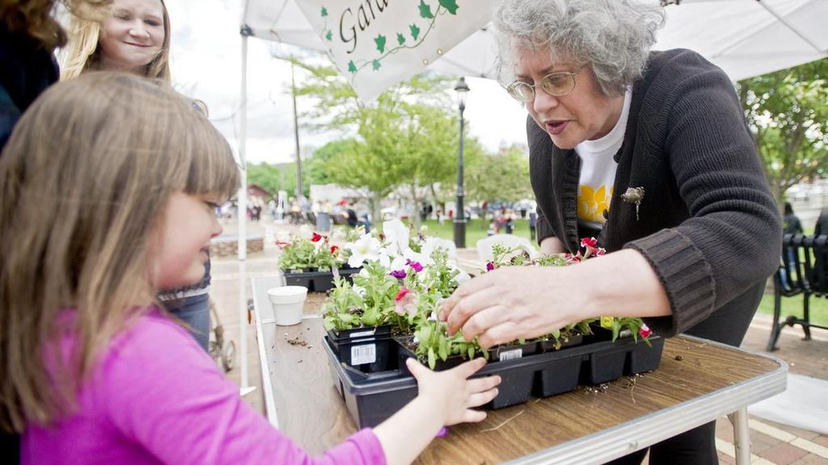Bellefonte Garden Club's Jane Wilson helps Keyondra Richner pick out a petunia to plant during the 2014 Big Spring Festival at Talleyrand Park.