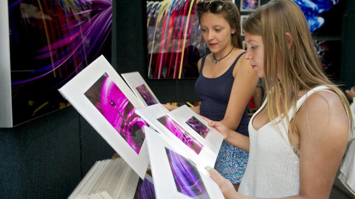 Kayla Swift and her sister, Chelsea, browse prints by photographer Pat Little during the Central Pennsylvania Festival of the Arts on July 11. Arts Fest is a top draw year after year.