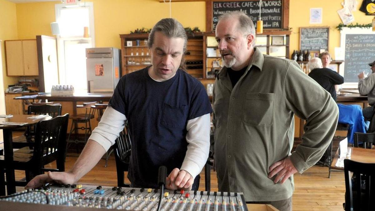 John Rattie, left, talks with Tim Bowser, owner of Elk Creek Cafe + Aleworks, while mixing sound for a 2011 show. Elk Creek will continue to host live music this year.