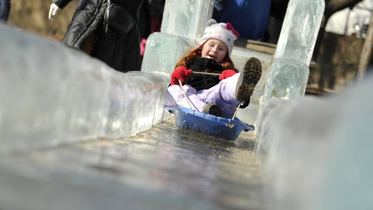 Noelle Collins, 7, of Williamsport, sleds down the ice slide in Sidney Friedman Park at the First Night State College celebration downtown.