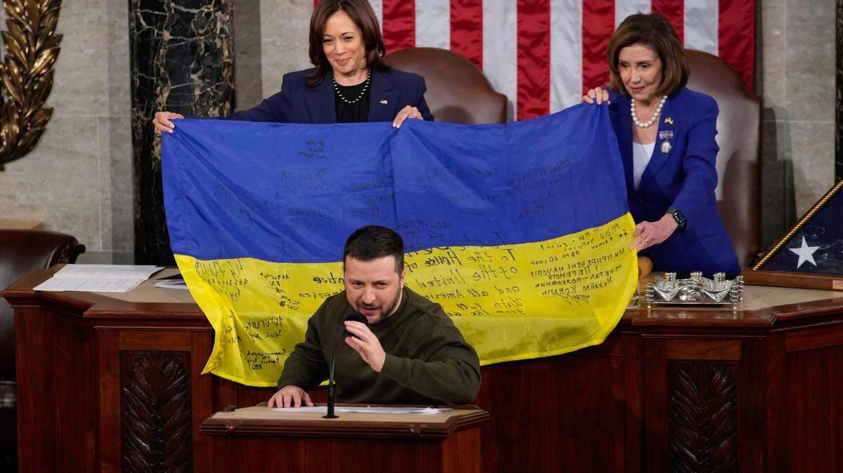 Vice President Kamala Harris, left, and House Speaker Nancy Pelosi are presented with a flag autographed by troops in Bakhmut, in Ukraine’s contested Donetsk province, by Ukrainian President Volodymyr Zelenskyy during an address to a joint meeting of Congress on Wednesday.