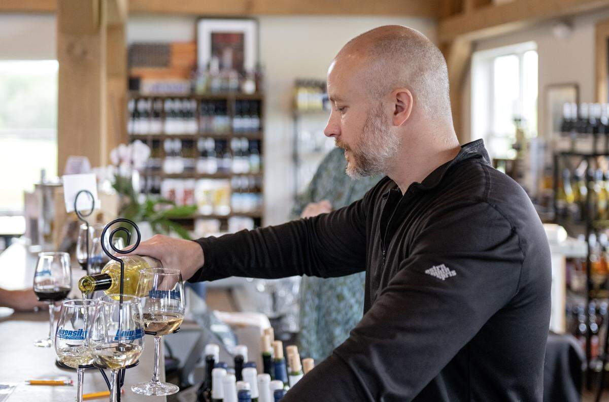 Jeff Proch pours a flight of wines for a customer at University Wine Company on Wednesday, May 13, 2026. 