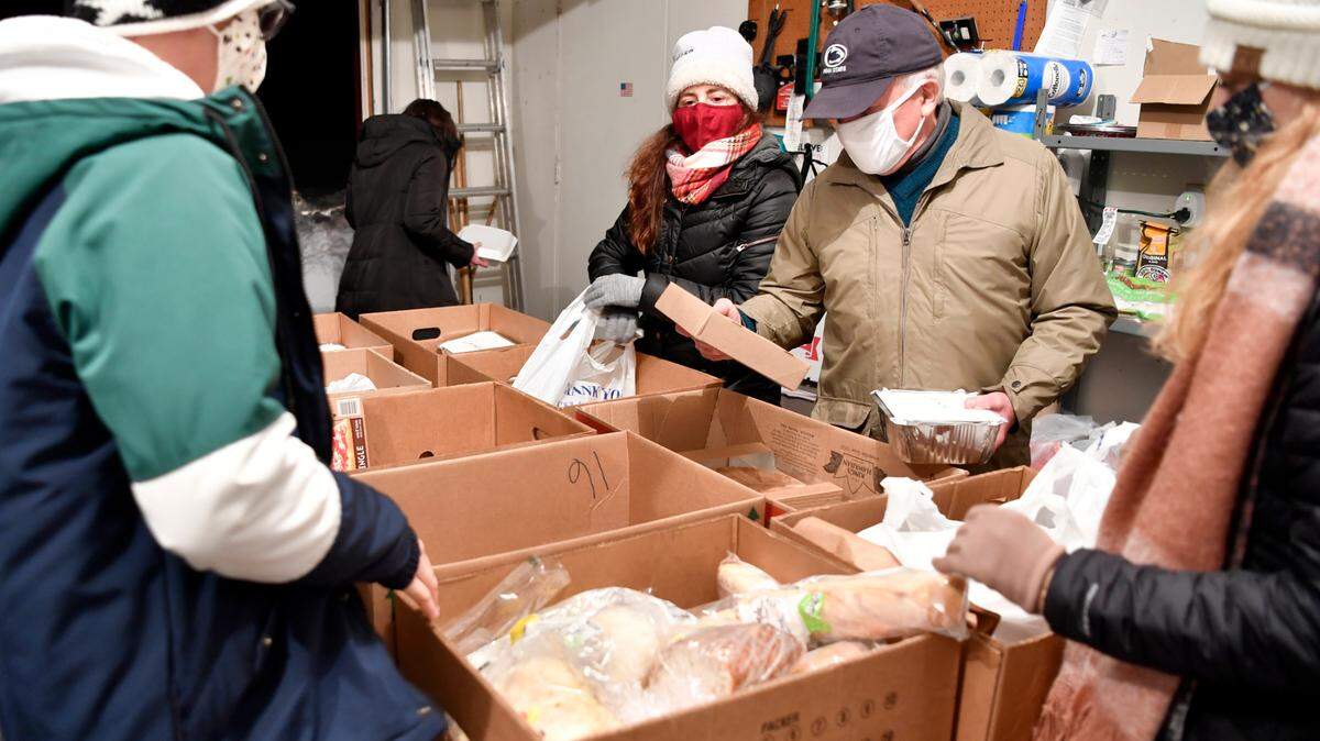 Volunteers Clarisa Capone and Hodge Barton help separate and package food on Dec. 17 to be delivered to families. Linda Barton created the English-Language Learner Family Fund to help students’ families with their most pressing needs.