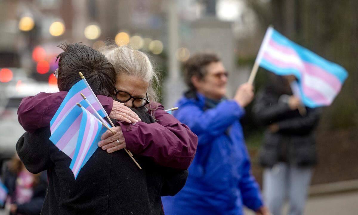 Katie Nurmi hugs Niko Geier after he read his poem “I am a Boy” during the Transgender Day of Visibility gathering hosted by the Centre LGBTQA Support Network at the Allen Street gates on Friday, March 31, 2023.