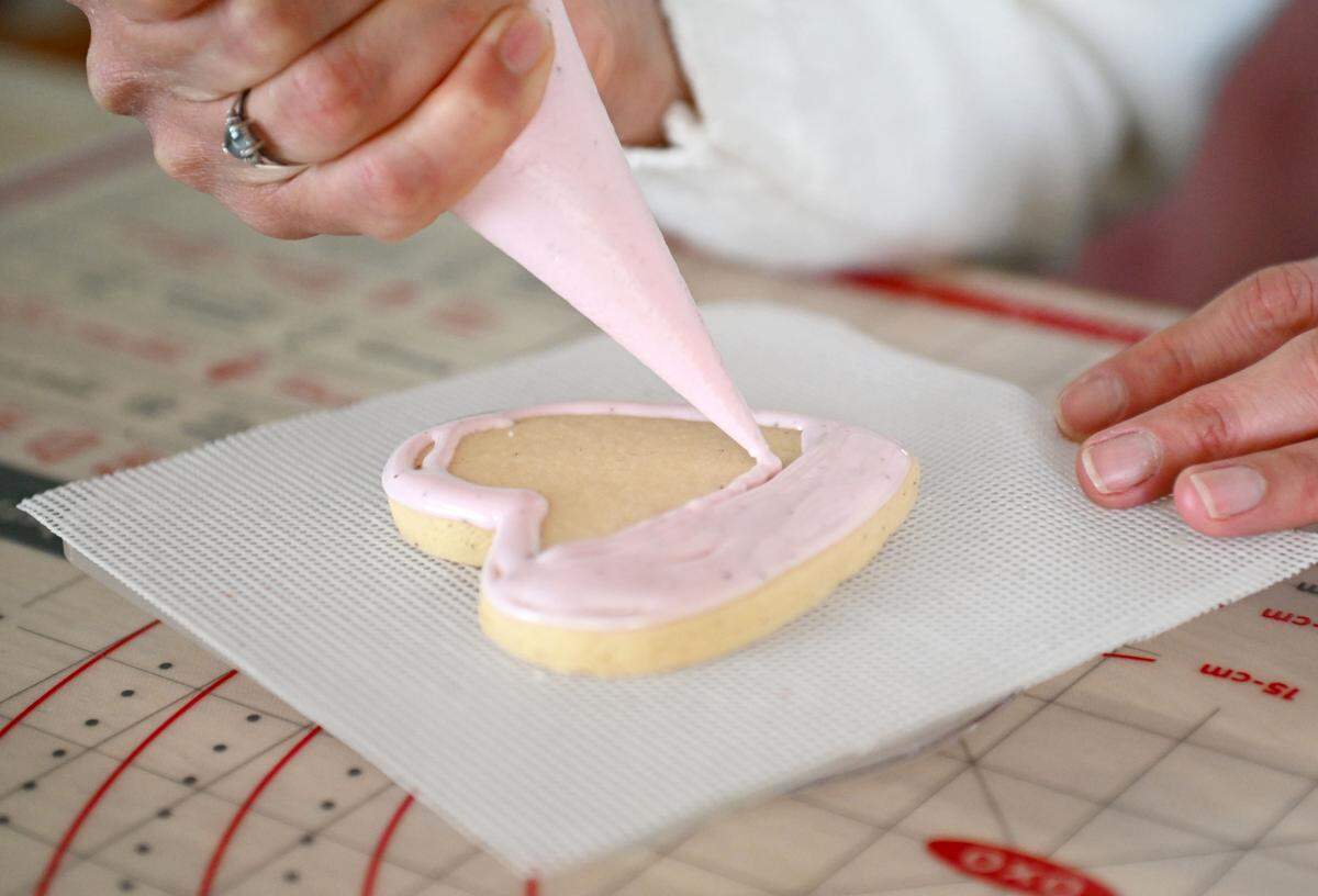 Yilka Thompson of Yilka’s Baking Studio decorates a heart-shaped cookie on Friday, Jan. 23, 2026.