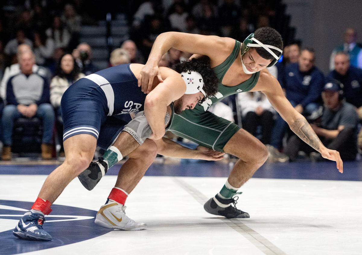 Penn State’s Beau Bartlett trips up Michigan State’s Jaden Crumpler in the 141 lb bout of the match on Friday, Jan. 10, 2025 in Rec Hall. Bartlett won by major decision, 12-3.