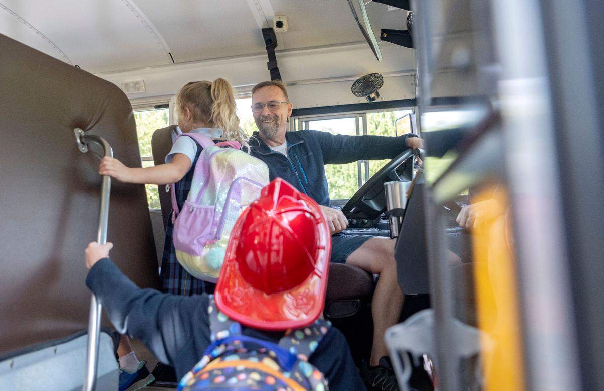 Driver Darrell Egolf talks to the students as they load his bus for their ride home from Our Lady of Victory on Friday, Sept. 22, 2023.