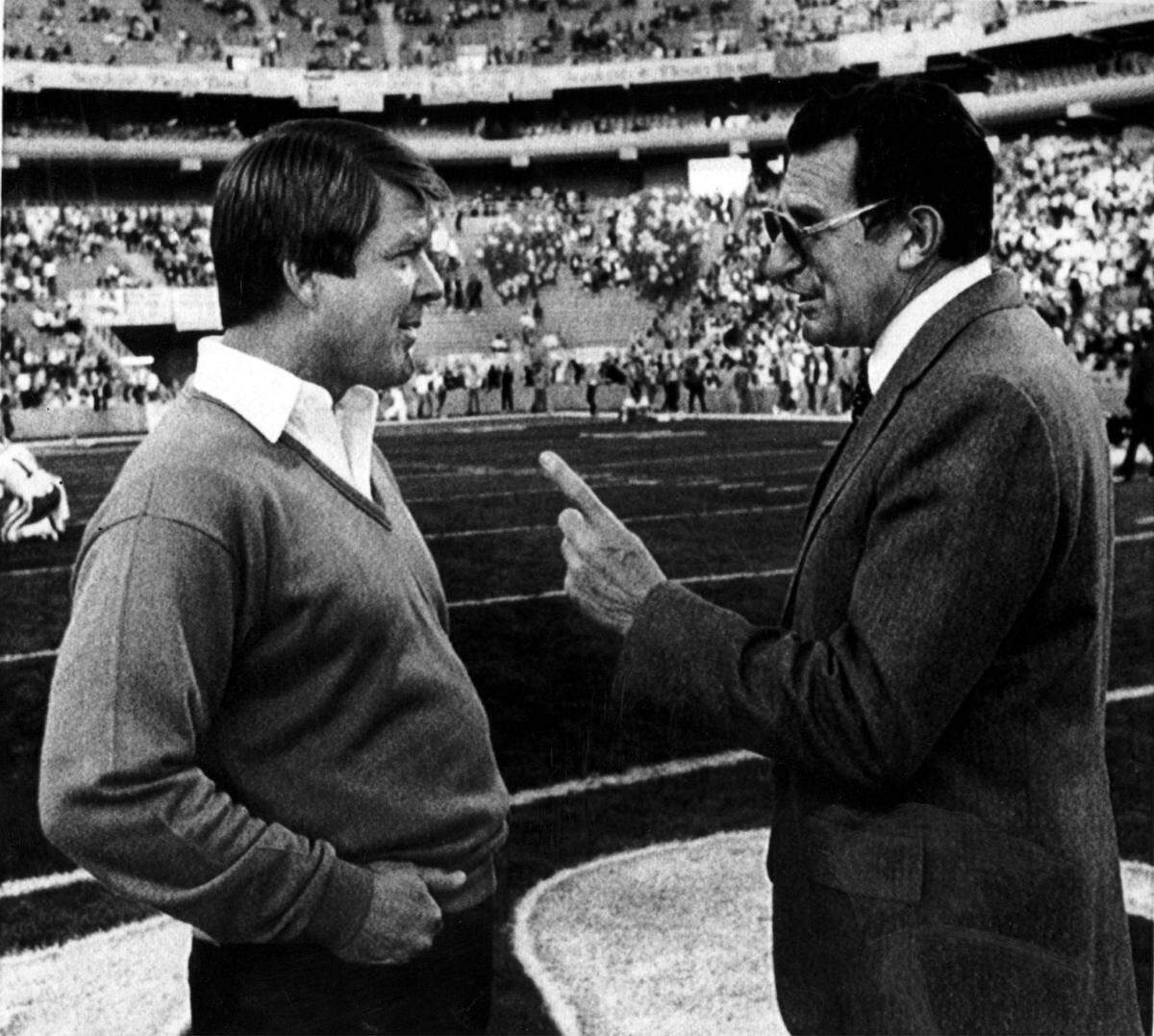 Penn State head coach Joe Paterno gestures as he talks with Miami head coach Jimmy Johnson on the field at Tempe’s Sun Devil Stadium where the Nittany Lions won 14-10 in the 1986 Fiesta Bowl.
