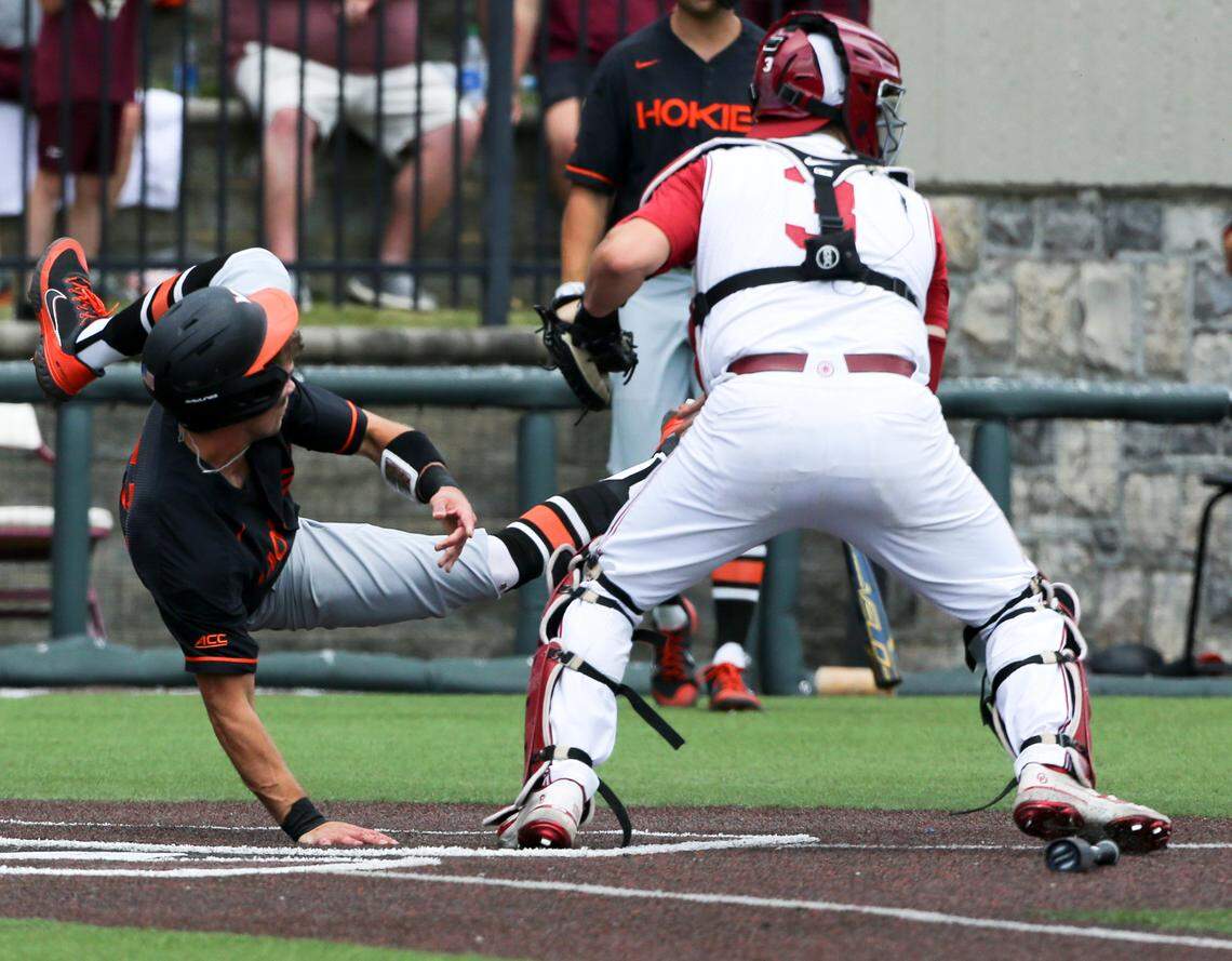 Virginia Tech’s Jack Hurley (31) flips after being tagged by Oklahoma catcher Jimmy Crooks (3) in the fifth inning of an NCAA college baseball tournament super regional game Saturday, June 11, 2022, Blacksburg, Va. (AP Photo/Matt Gentry)