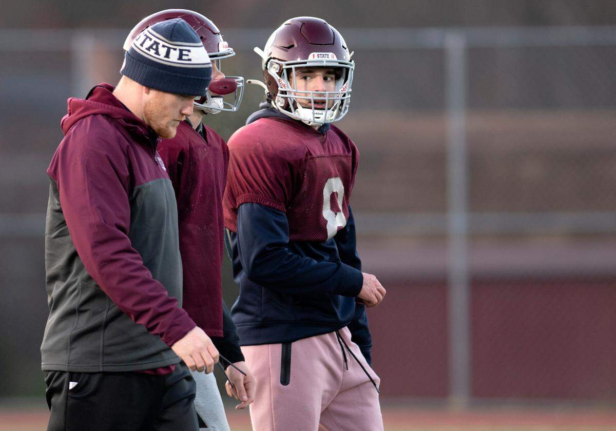 State College’s Calvin Roan walks with a teammate and assistant coach during football practice on Tuesday, Nov. 30, 2021. The Little Lions will face Mount Lebanon in the PIAA class 6A semifinals on Saturday.