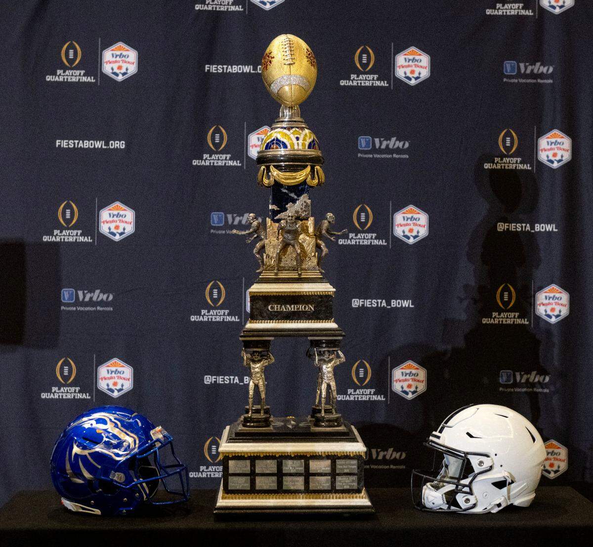 The Fiesta Bowl trophy on display with a helmet from Boise State and Penn State on Monday, Dec. 30, 2024 at the Camelback Inn.