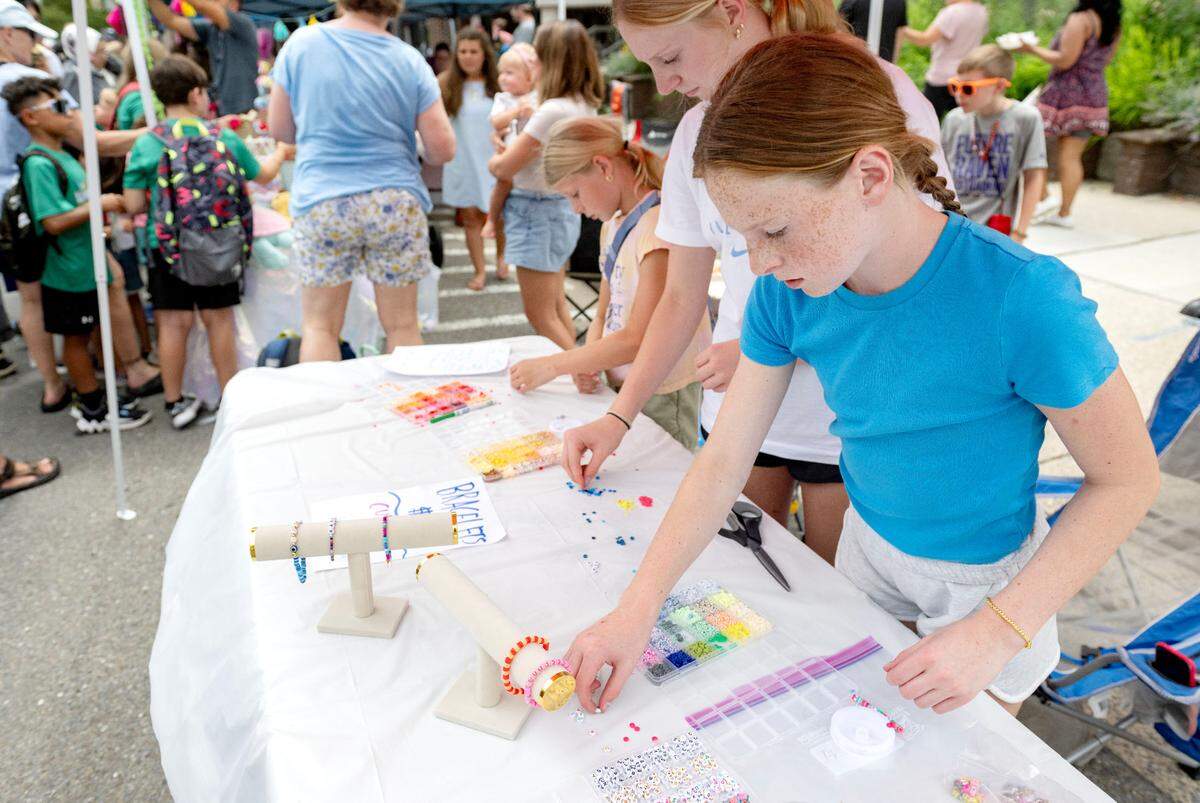 Shea Cawley, 11, makes a custom bracelet during the Central Pennsylvania Festival of the Arts Children and Youth sidewalk sale on Wednesday, July 9, 2025.