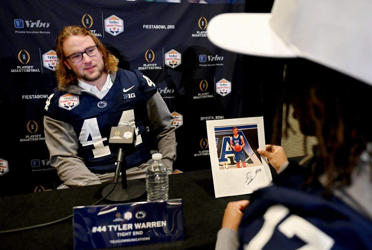Penn State tight end Tyler Warren laughs with teammates after they asked him to sign an old photo of him during media day for the Fiesta Bowl on Sunday, Dec. 29, 2024.