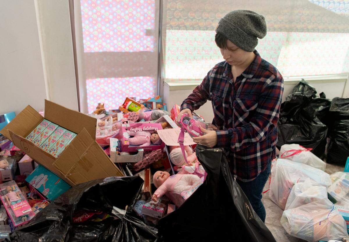Jem Neumann picks out toys for a family at the Toys for Tots Unregistered Site on Tuesday.