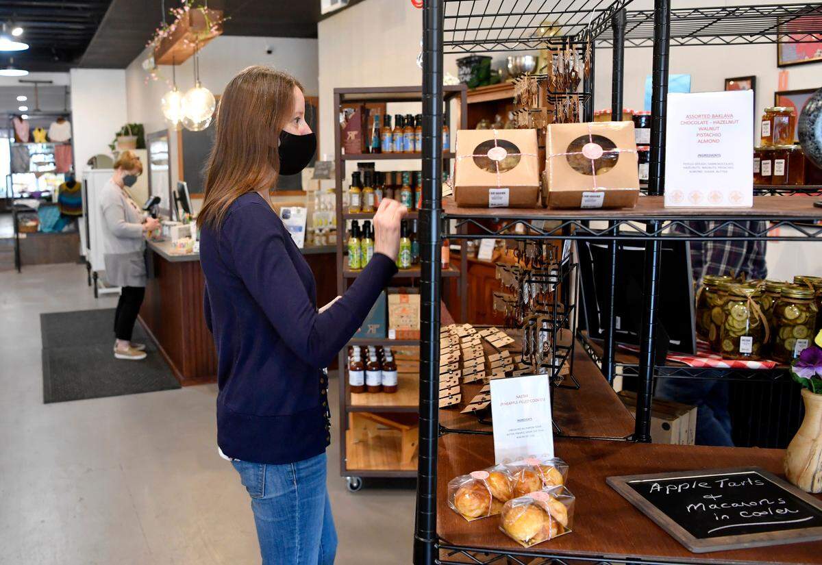 Andrea Skirpan straightens items on a vendors display at Belle Mercantile in April 2021.