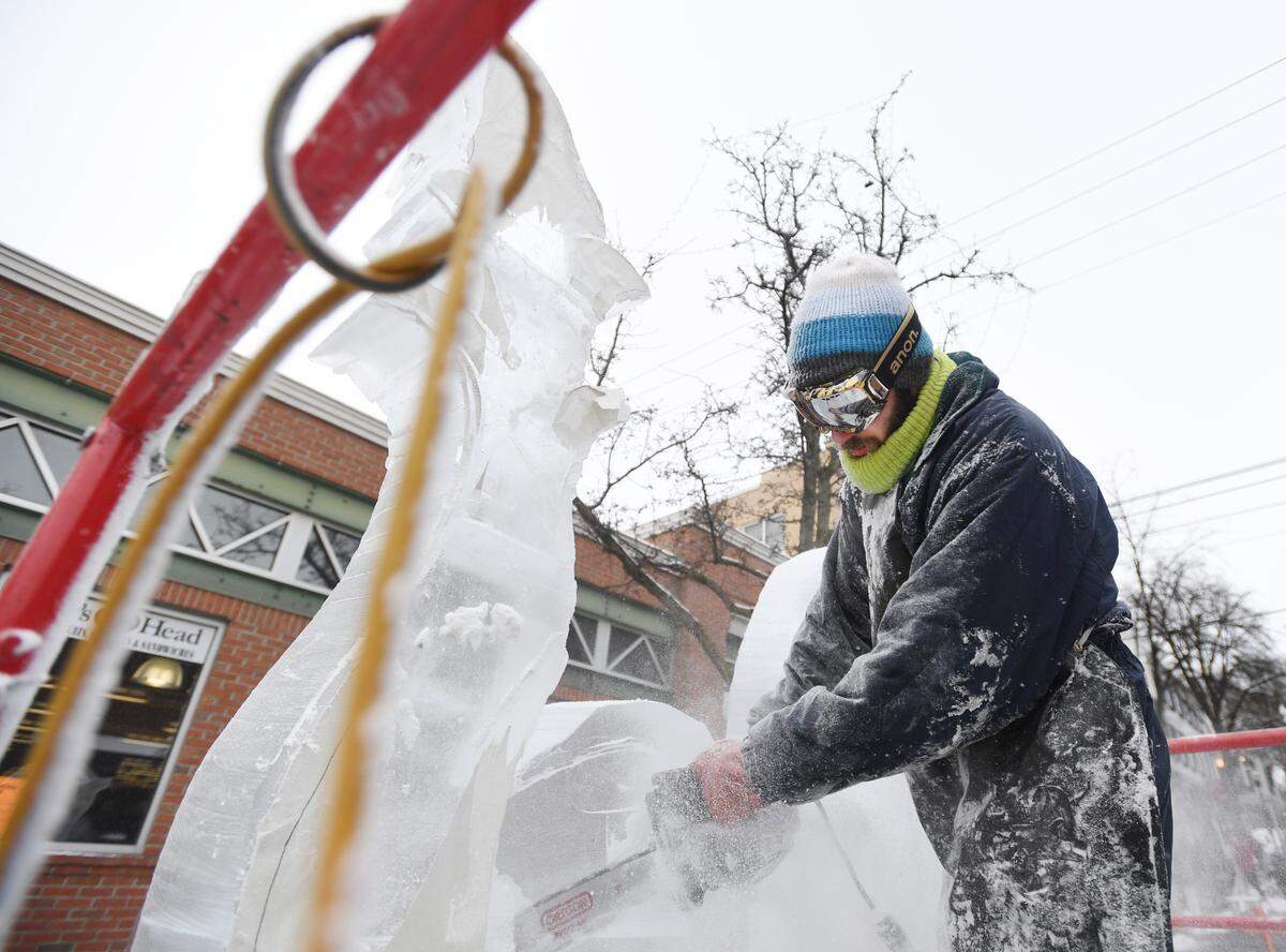 Jared McAllister sculpts a hybrid seahorse ice sculpture during First Night State College in 2017 in downtown State College.