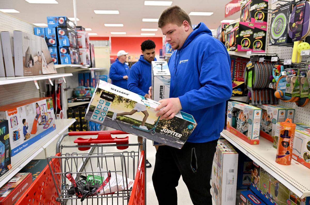 Penn State football player Cooper Cousins loads his shopping cart with scooters as he helps West Shore Home shop for Toys For Tots on Monday, Dec. 2, 2024 at Target.