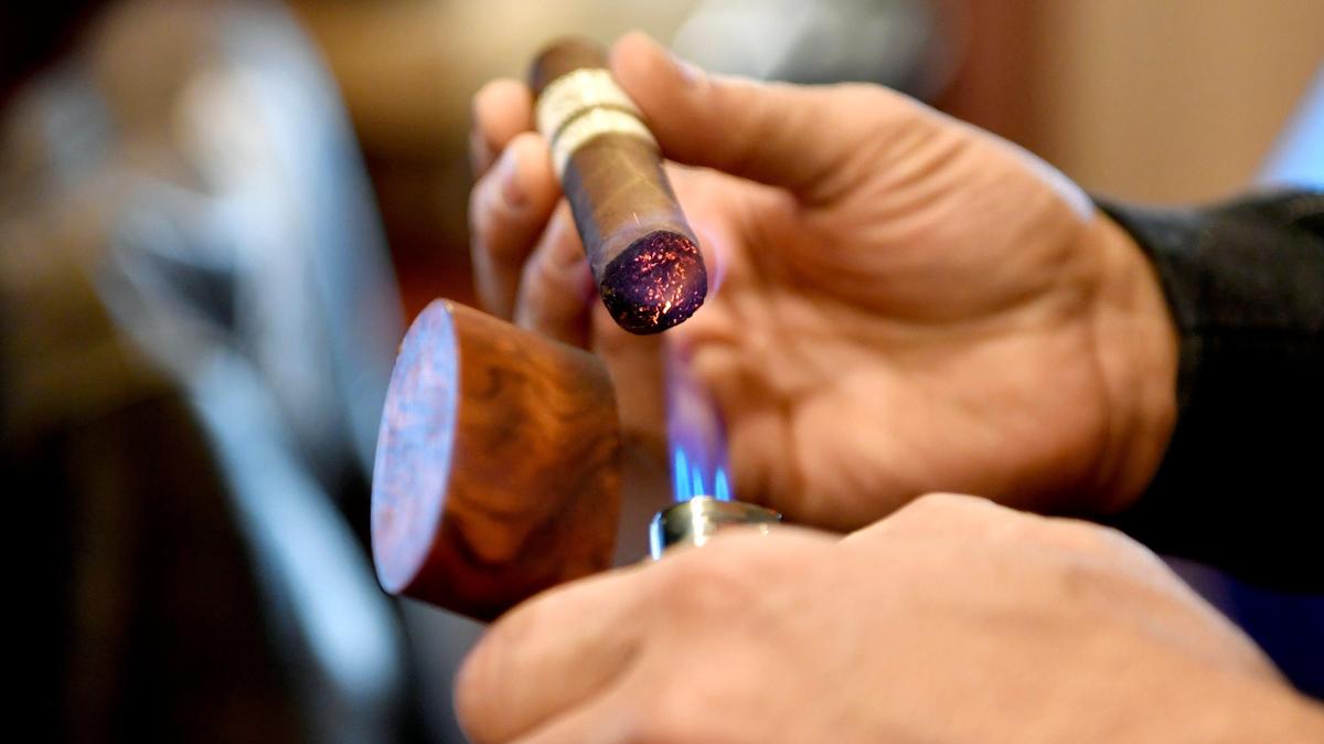Your Cigar Den owner Tony Ghaffari lights a cigar on Feb. 19, 2020. Ghaffari plans to open a second location this week.