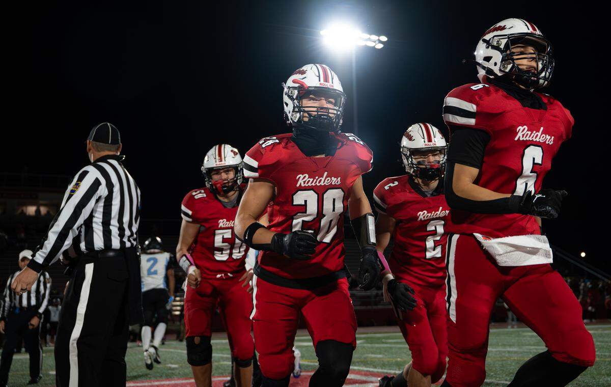 Bellefonte’s Jackson Long (28) runs off the field with teammates after the coin toss before a Friday night football game against Greater Johnstown in Bellefonte, Pa., on Oct. 31, 2025. The Red Raiders beat the Trojans 34-0.