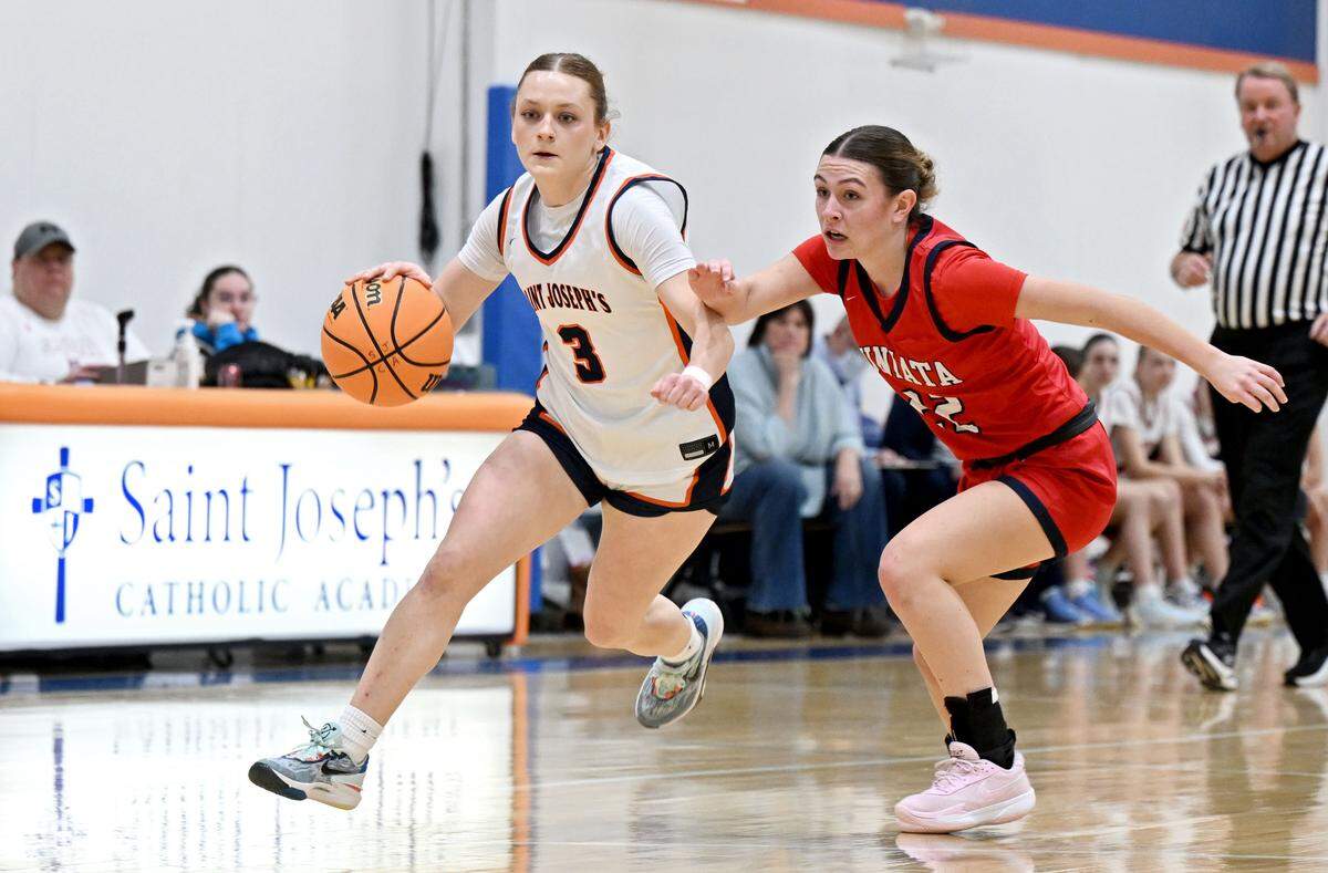 Saint Joseph’s Catholic Academy’s Naomi Crispin dribbles down the court with the ball around Juniata’s Aubryn Deihl during the game on Monday, Feb. 9, 2026.