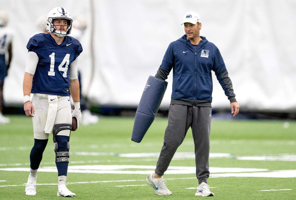Penn State offensive coordinator Mike Yurcich talks to quarterback Sean Clifford as they run a drill during practice on Wednesday, Oct. 19, 2022.