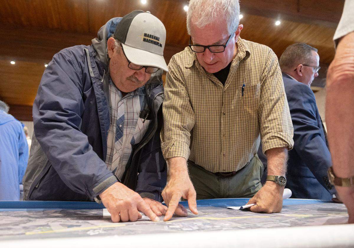Centre County Commissioner Steve Dershem looks at an area of Route 322 on a map that features the central alternative route with a community member during the PennDOT public scoping meeting about the State College Area Connector Project on Thursday, May 9, 2025 at the Wyndham Garden State College.