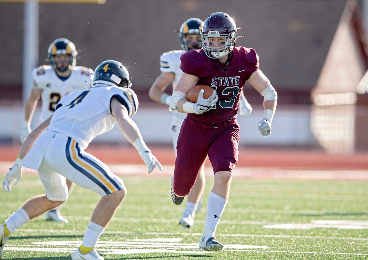 Mt. Lebanon defenders try to stop State College’s Brady Bendik as he runs down the field with the ball during the PIAA class 6A semifinal game on Saturday, Dec. 4, 2021 at Mansion Park. Mt. Lebanon won, 49-28.