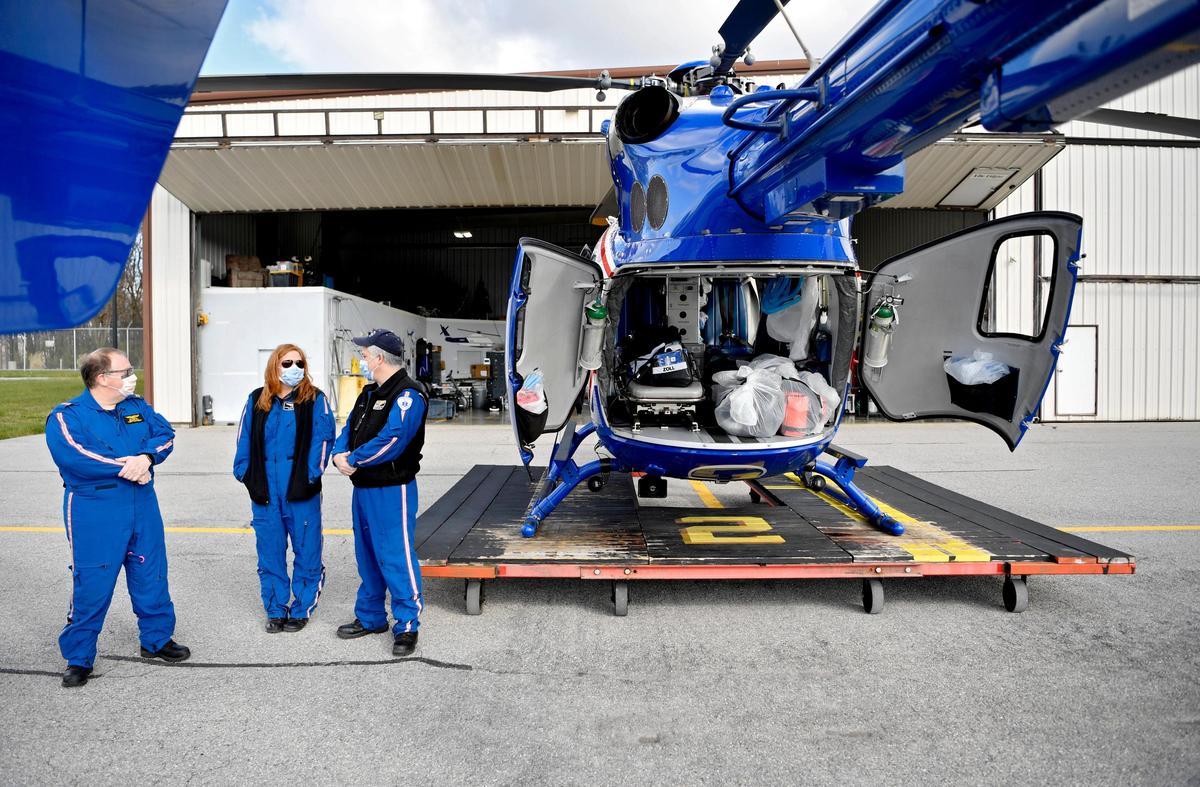 Crew members of Life Flight stand next to the helicopter at the University Park airport hanger on Wednesday, April 22, 2020. Geisinger wants to remind the public that emergency crews are prepared to help with medical emergencies.