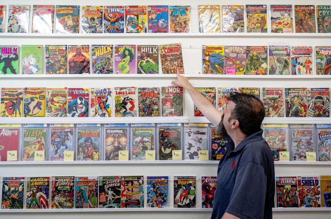 Justin Behrens talks about some of the books offered at his shop in the Westerly Plaza, Comic Cove, on Monday, May 20, 2024.