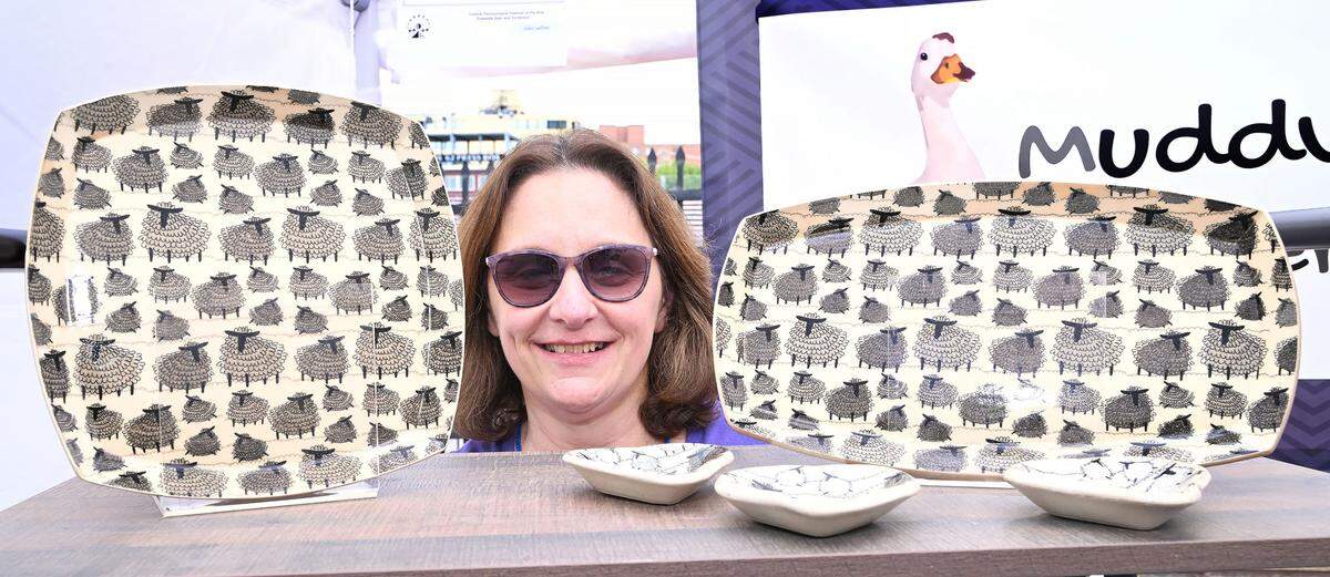 Kathie Kmmerdiener of Muddy Duck Designs, stands by her art work at the 57th Central Pennsylvania Festival of the Arts in State College Thursday, July 13, 2023. (For the CDT/Steve Manuel)