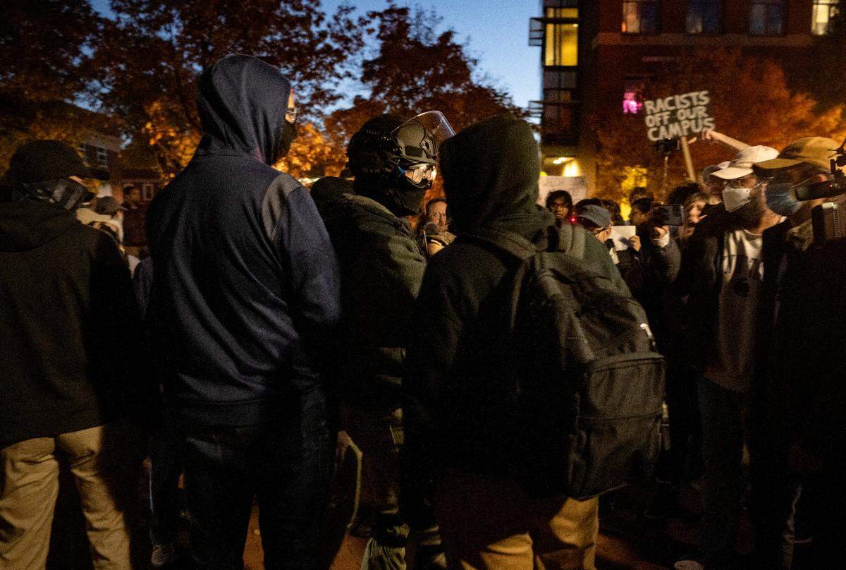 Protesters gather around a group of people outside of the Thomas Building on Monday, Oct. 24, 2022.