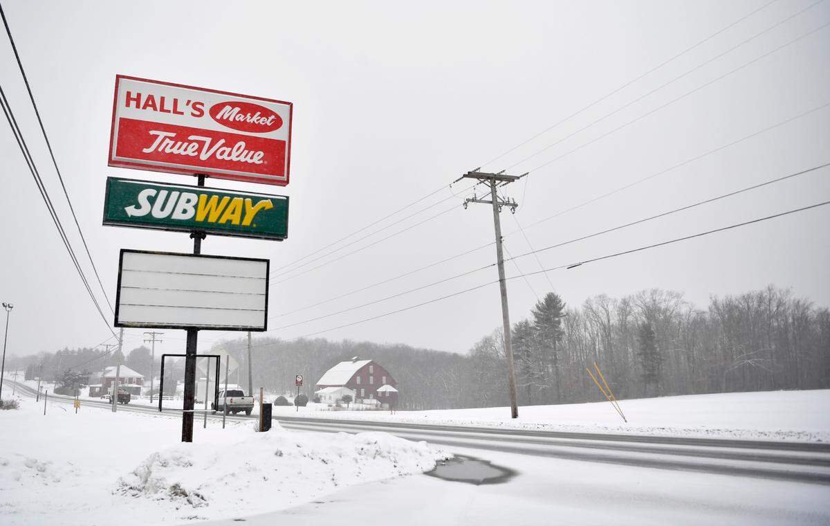 Cars travel past the sign for the now-closed Hall’s Market, True Value and Subway on Jan. 28.