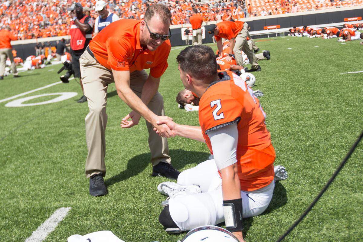 Mike Yurcich (left) shakes hands with Mason Rudolph (right) before the Oklahoma State Cowboys’ game vs. the TCU Horned Frogs on Saturday, September 23, 2017 at Boone Pickens Stadium in Stillwater, Oklahoma.