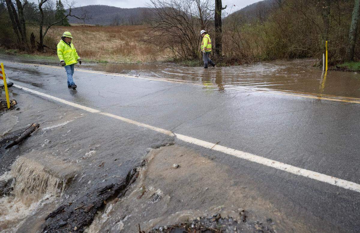 PennDot works put up signs and try to clear debris as water floods a portion of Buffalo Run Road on Wednesday, April 3, 2024.