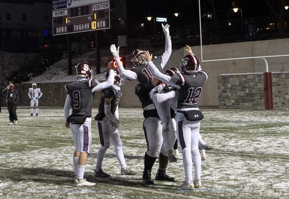 State College’s Michael Gaul is lifted up by teammates and celebrates after beating McDowell in the third overtime 57-50 on Friday, Nov. 18, 2022.