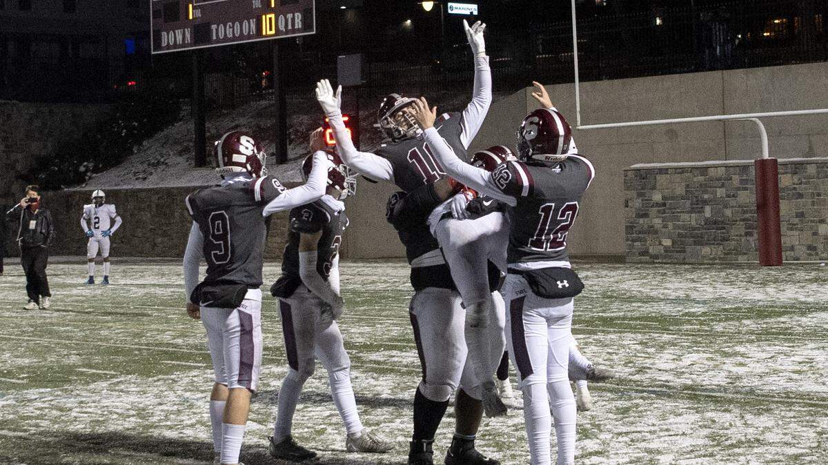State College’s Michael Gaul is lifted up by teammates and celebrates after beating McDowell in the third overtime 57-50 on Friday, Nov. 18, 2022.