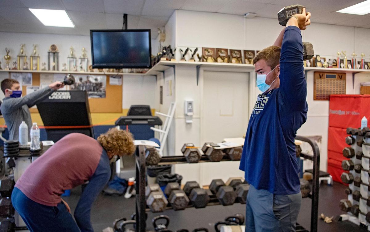 Bald Eagle Area football players wear masks and socially distance for a weightlifting session with some equipment blocked off on Friday, July 10, 2020. Players also wore long sleeves and pants to weight lift, along with constant sanitation of equipment.