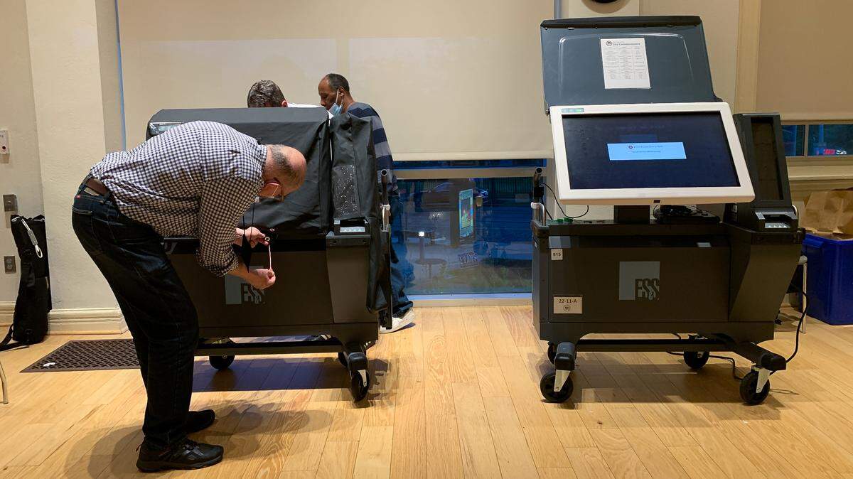An election worker in Philadelphia, Pennsylvania examines an ExpressVoteXL voting machine during the 2022 primary.