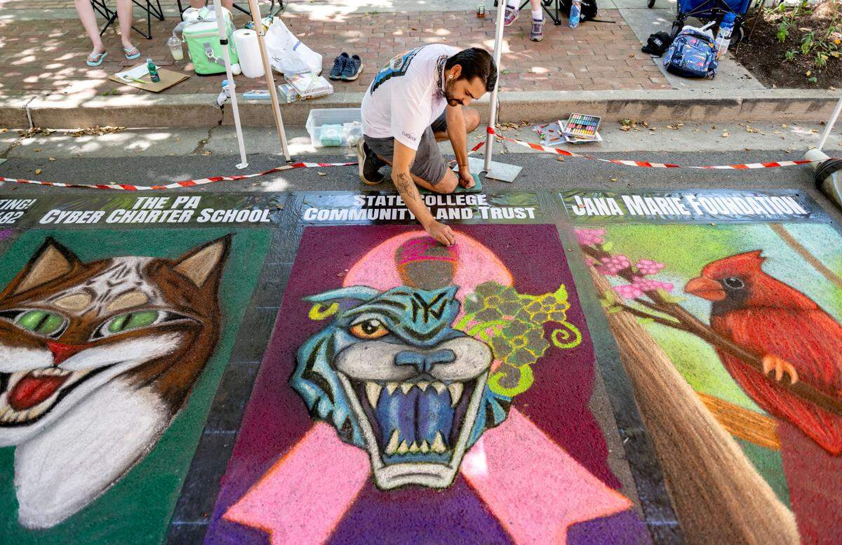 Willy Zayas IV works on the Italian street painting rendition of his original piece “My Nurturing Guardian” at the Central Pennsylvania Festival of the Arts on Friday, July 12, 2024.