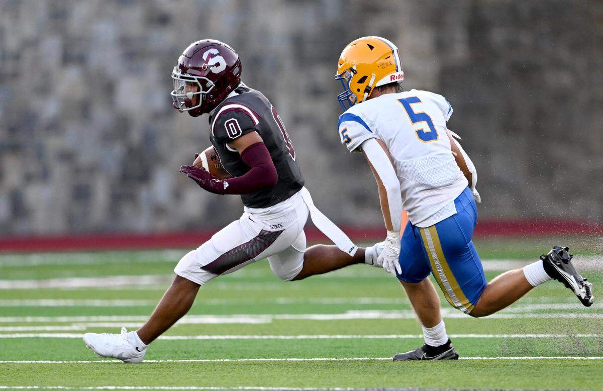 State College’s D’Antae Sheffey cuts around Downingtown East’s Dimitri Soublis during the game on Friday, Sept. 1, 2023.