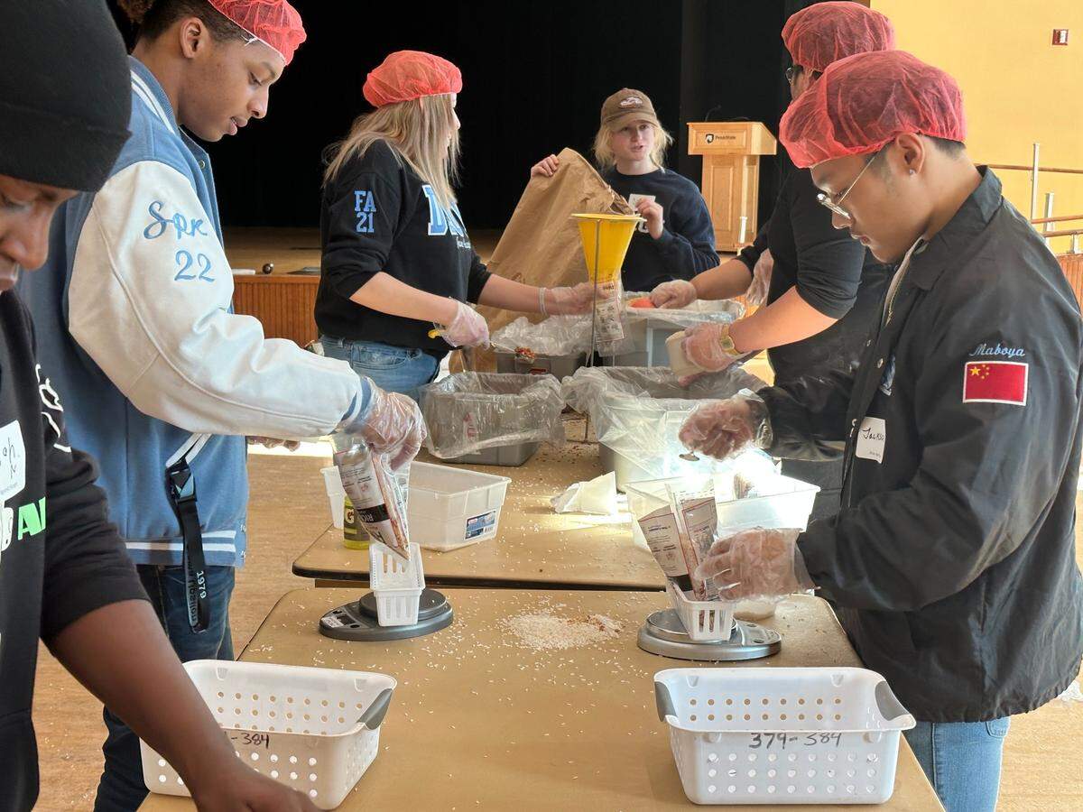 Penn State students Xavier Viala and Jackson Fung weigh bags of rice and vegetables for Rise Against Hunger during the Martin Luther King Jr. Day of Service on Monday, Jan. 16, 2023, in the HUB-Robeson Center’s Heritage Hall.