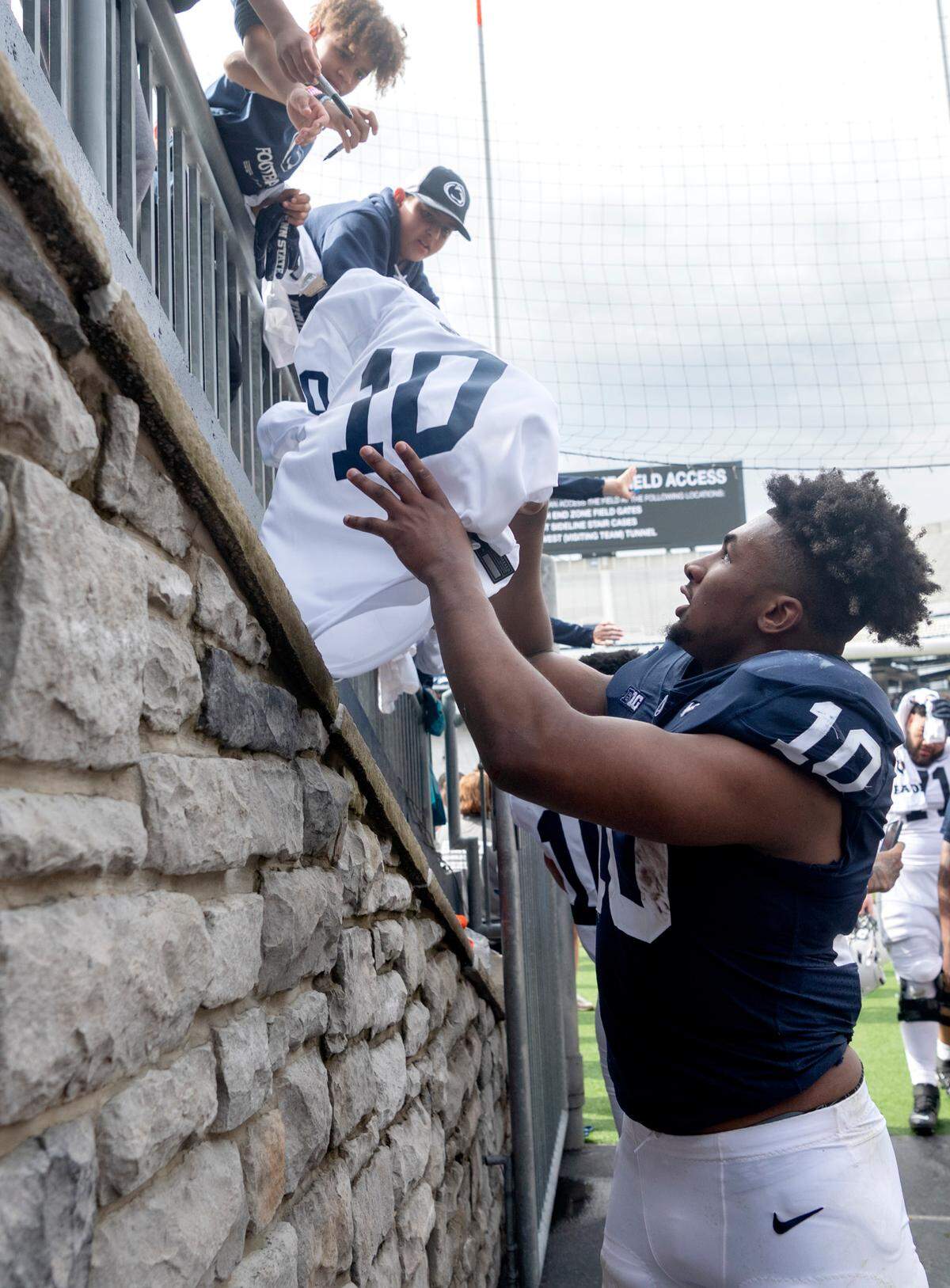 Penn State running back Nick Singleton signs a jersey for a young fan after the Blue-White game on Saturday, April 15, 2023.