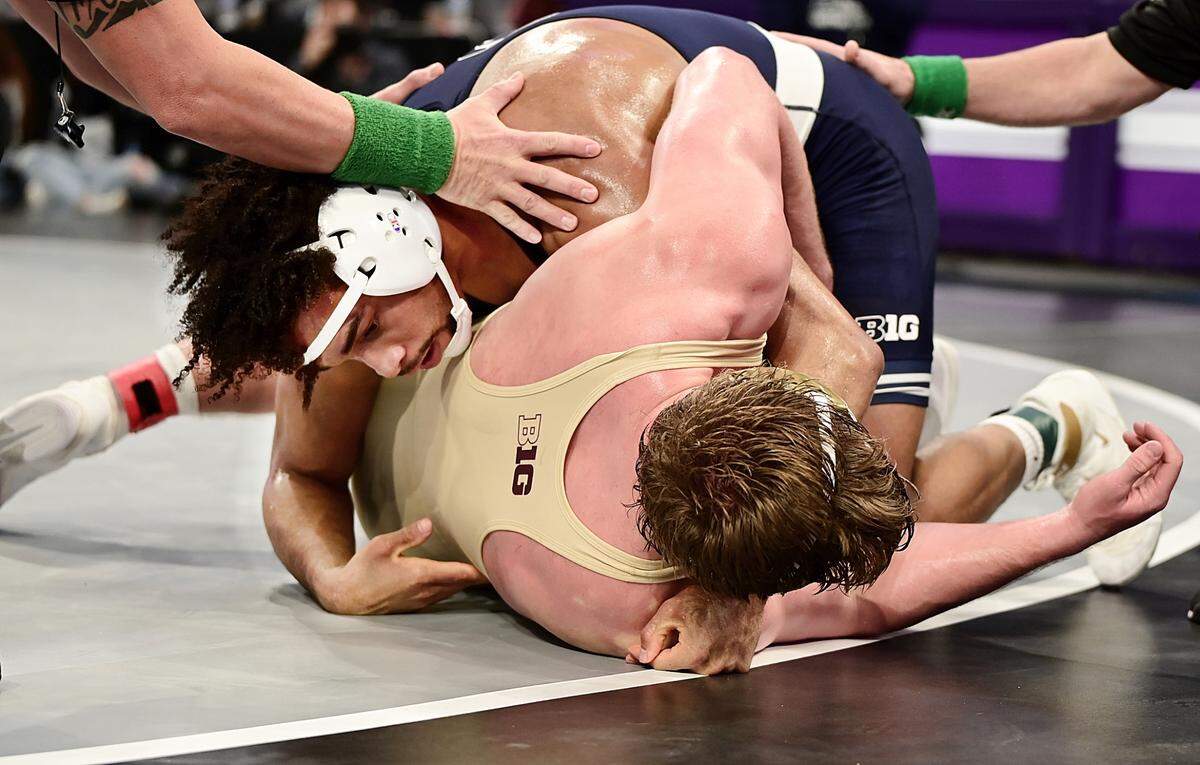 Penn State’s Carter Starocci scores the winning takedown on Minnesota’s Max McEnelly in their 184-pound finals match of the Big Ten championships on March 9 inside Welsh Ryan Arena in Evanston, Ill. Starocci edged McEnelly, 8-5, in sudden victory for his third and final Big Ten title.