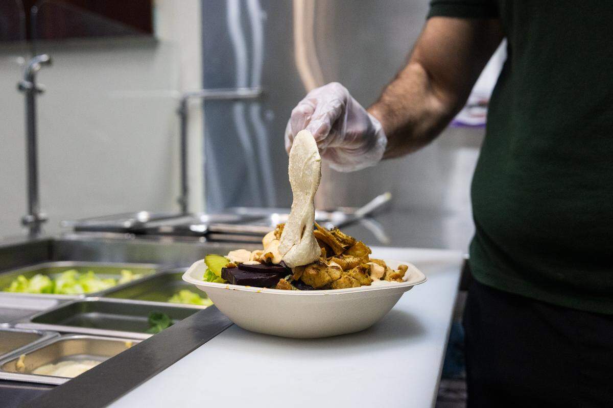 Mohammad Hayajnehon spreads some humus as he makes a Beirut bowl in Fava Kitchen on Sunday, Feb. 8, 2026 in State College. 