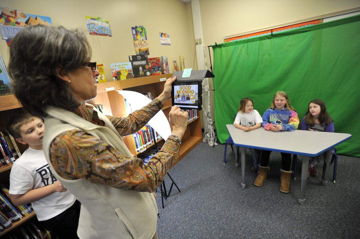 Reading specialist Mary Conner-Righter films students in April 2016 for a mock television broadcast based on a book the students read at Miles Township Elementary School. 