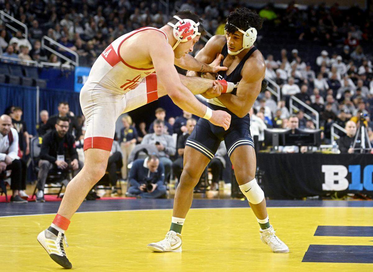Nebraska’s Mikey Labroila tries to get away from Penn State’s Carter Starocci in the 174 lb championship bout of the Big Ten wrestling championships at the Crisler Center on Sunday, March 5, 2023.