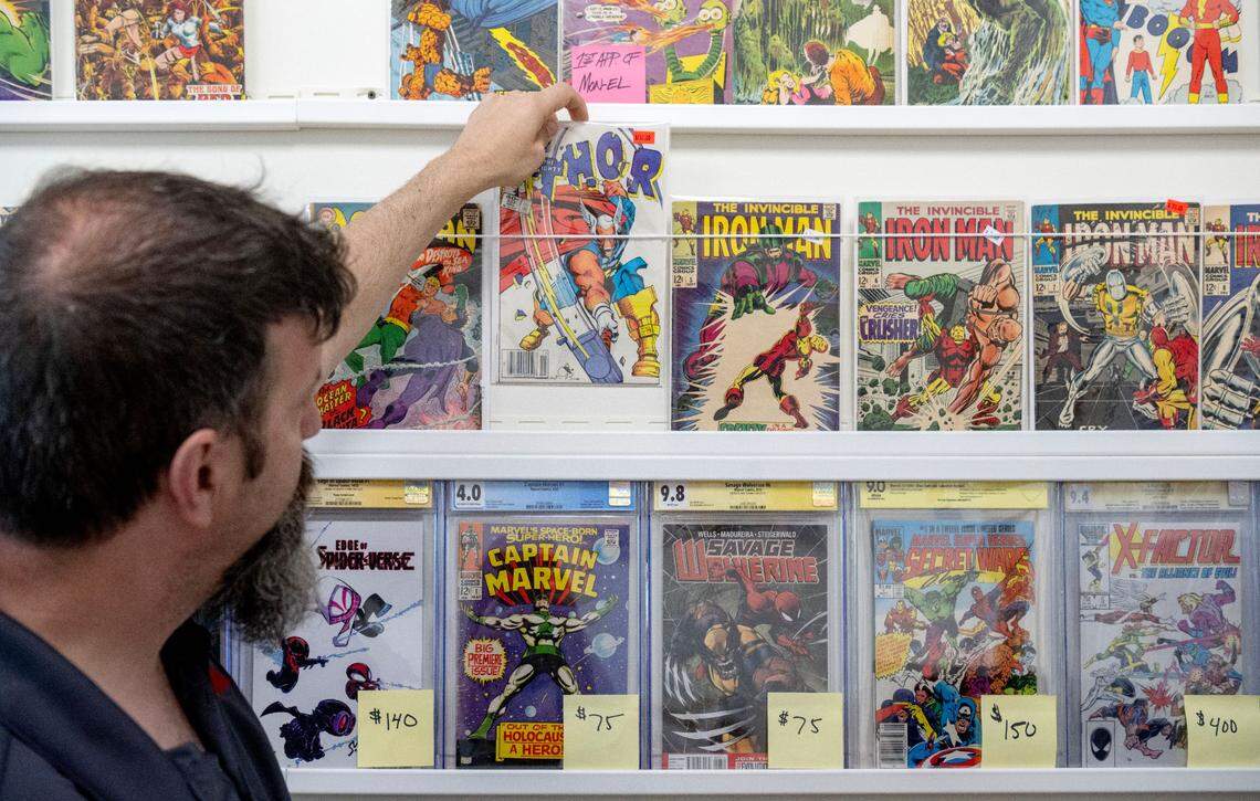 Justin Behrens talks about the difference between some of the comics he offers at his shop Comic Cove on Monday, May 20, 2024.